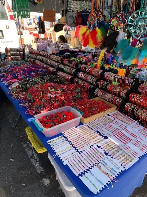 A market stall displaying bracelets, dreamcatchers, and other accessories.