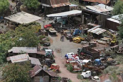 An elevated view of an outdoor yard filled with vintage buildings, old trucks, and machinery.