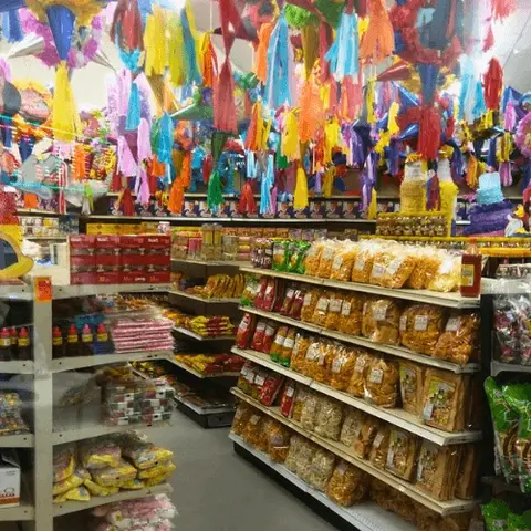 A store interior filled with hanging piñatas and shelves of snacks.