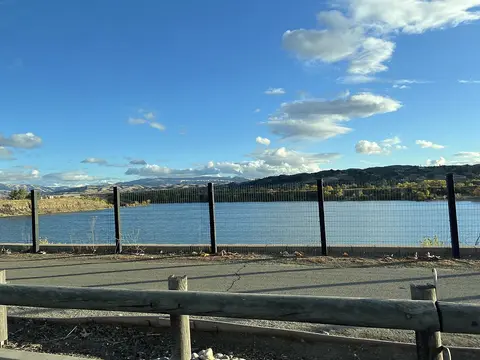A view of a lake and hills under a blue sky.