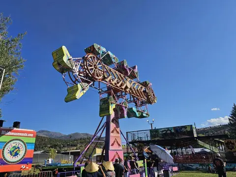 An amusement park ride stands against a blue sky.
