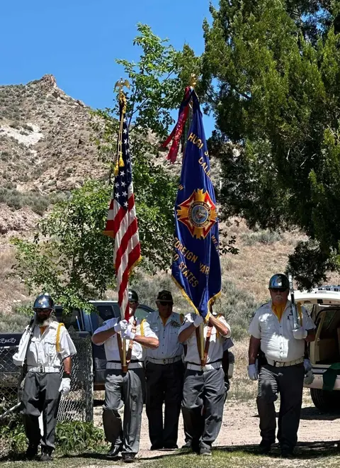 A color photograph of people carrying flags outdoors.