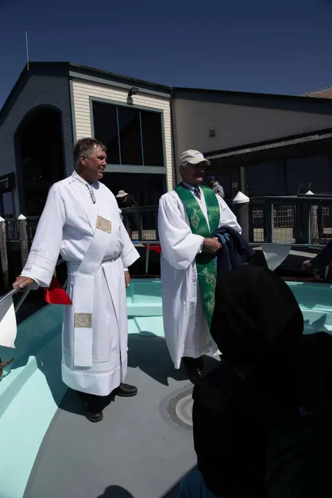 Two men in religious vestments stand on a boat.