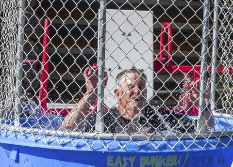 A man reacts inside a dunk tank filled with water.