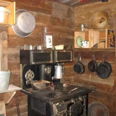 A rustic wooden kitchen interior with a vintage cast iron stove.