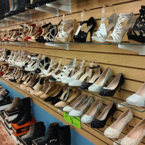 Shelves in a store display various styles of women's shoes and boots.