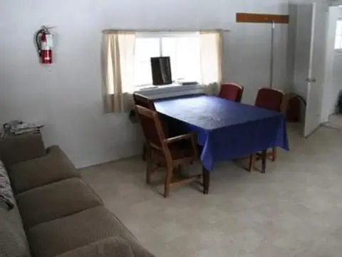 An interior view of a room with a couch, table, and chairs.