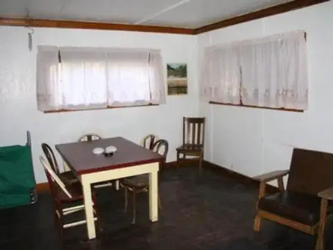 A photograph showing the interior of a room with a dining table and chairs.