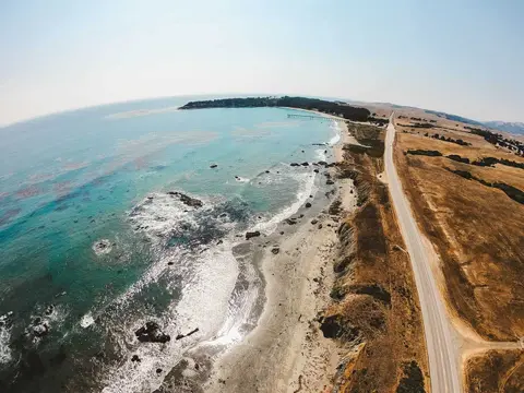 An aerial view of a coastline with a road running alongside the beach.