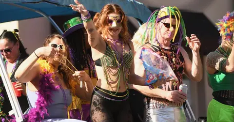 People in festive costumes celebrating on a float during an event.