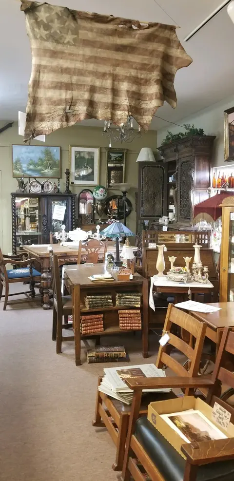 An interior view of an antique store filled with various furniture and items.