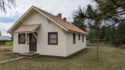 An exterior view of a small cabin with a shingled roof.