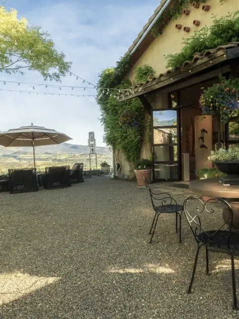 A scenic outdoor patio area with seating and a view of rolling hills.