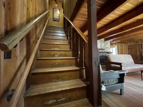 A wooden staircase inside a rustic cabin.