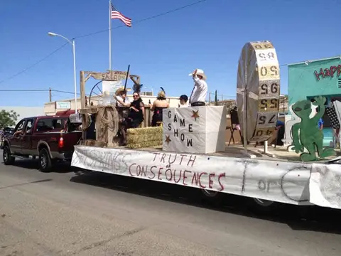 A parade float themed around Truth or Consequences with people dressed in costume.