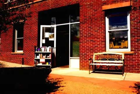 An exterior view of a brick building with a bench outside.