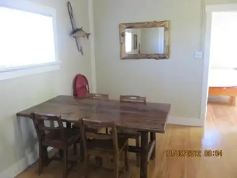 A dining area with a wooden table and chairs inside a room.