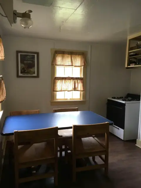 An interior shot of a kitchen with a dining table and chairs.