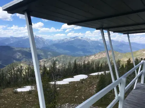 A view of mountains and forest from a covered observation deck.