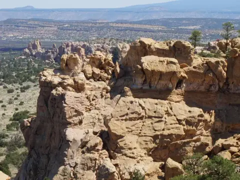 A wide view of rugged sandstone rock formations and a desert landscape.