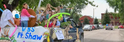 A truck with children riding on a decorated parade float.