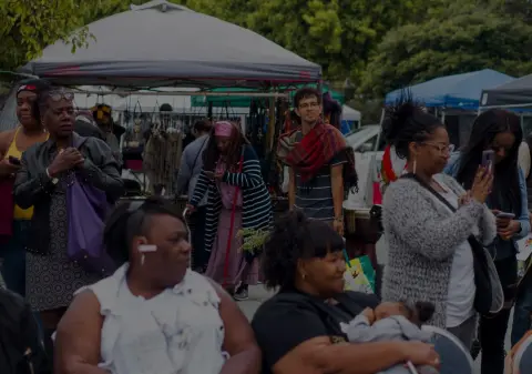 A crowd of people gathering at an outdoor market or event.