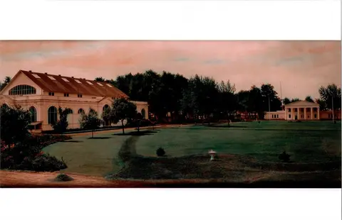 A panoramic exterior view of large buildings and expansive lawns with trees.