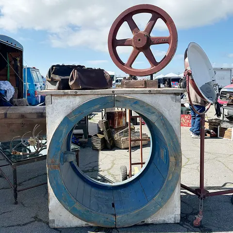 Various vintage items and machinery parts are on display outdoors.