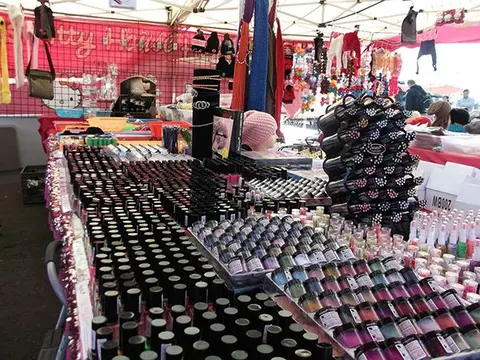 A market stall displays a large collection of beauty products and accessories.