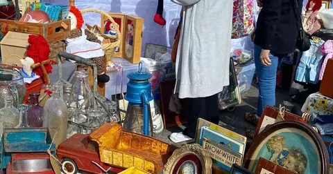 People browse through items at a flea market or yard sale.