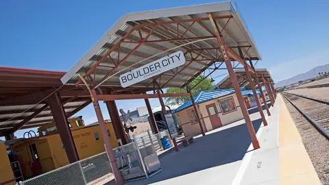 A train station platform under a metal canopy.