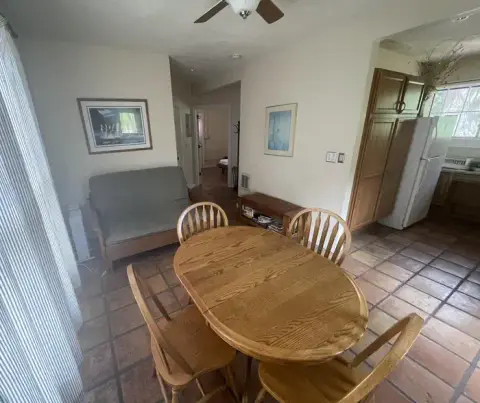 A dining area with a wooden table and chairs inside a home.