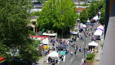 An elevated view of an outdoor street market with tents and people.
