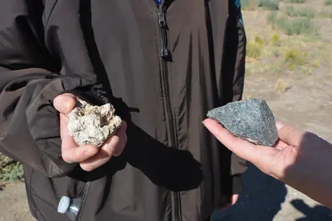 A person holding up two different rocks in their hands.
