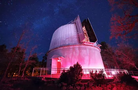 An observatory building under a starry night sky.