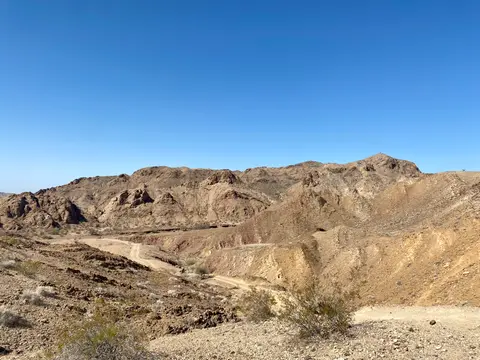A desert landscape with mountains under a clear blue sky.