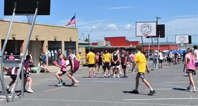 People playing basketball on an outdoor court.