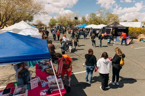 An outdoor street market with various tents and vendors.