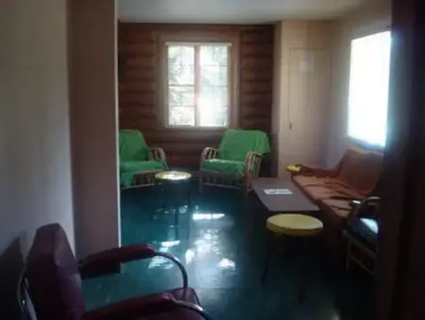 Interior view of a rustic room with a log wall and furniture.