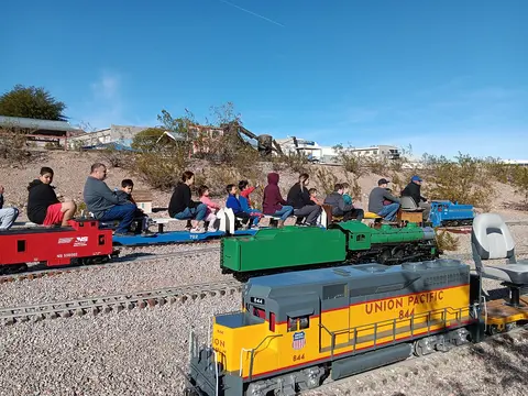 People ride on a miniature train.