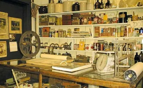 An interior shot of a historic shop with shelves full of old containers and merchandise.
