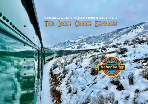 A train travels through a snowy mountain landscape.