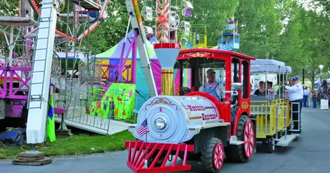 A colorful trackless train ride at an amusement park.