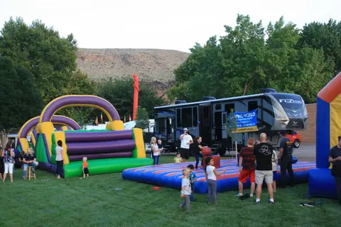 People enjoy outdoor activities with inflatable bounce houses and a recreational vehicle.