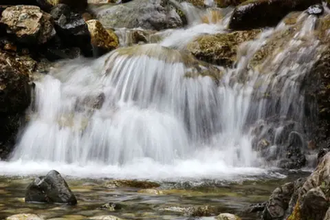 Water flows over rocks in a small stream.