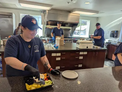 People preparing food in an industrial kitchen.