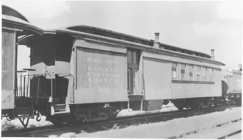 A historic black and white photograph of a railway baggage car.