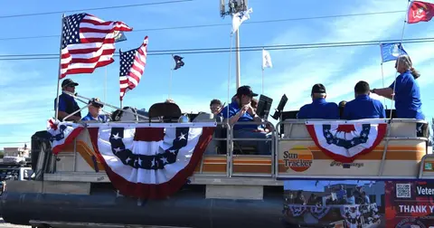 A decorated boat float carrying people in a parade.