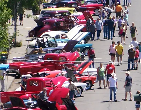 An elevated view of a car show with classic cars and visitors.