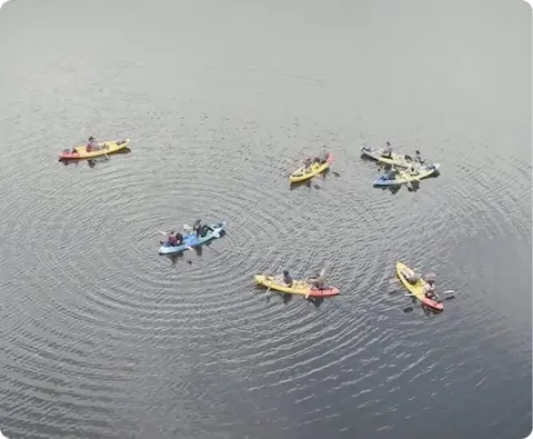An aerial view of several kayakers on the water.
